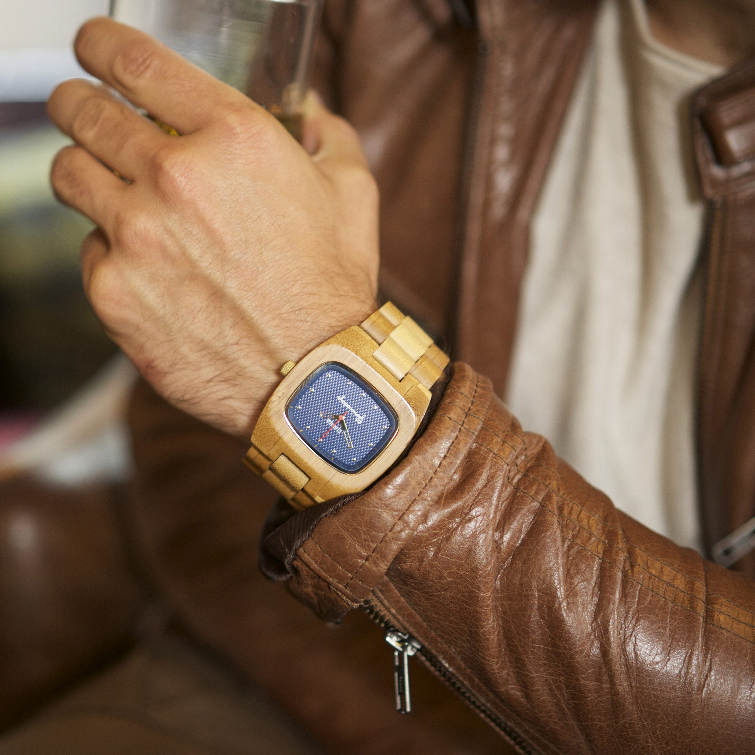 Clipper bamboo watch wrist shot with brown leather jacket.